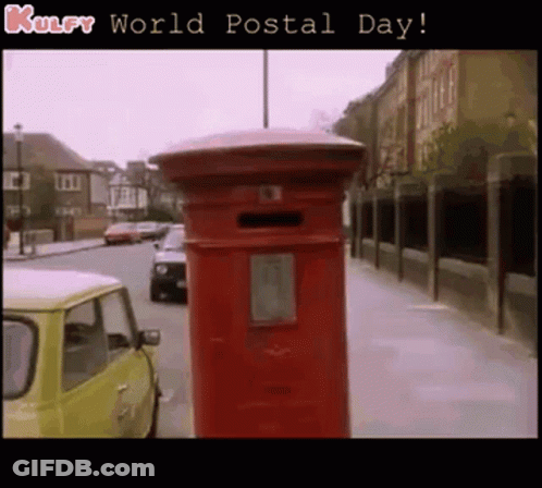 A Red Mailbox On The Side Of A Street With The Words Kulfy World Postal Day Below It GIF