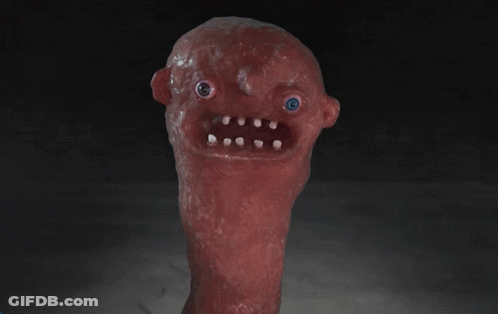 A Red Monster With A Blue Eye And White Teeth Is Looking At The Camera GIF