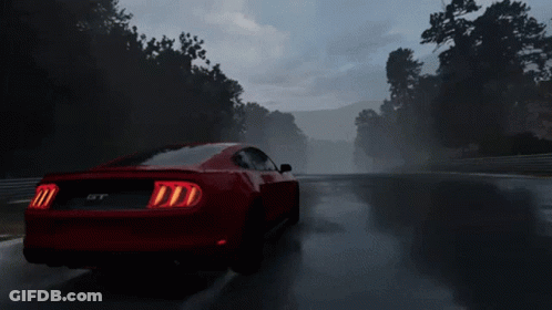 A Red Mustang Gt Is Driving On A Wet Road GIF