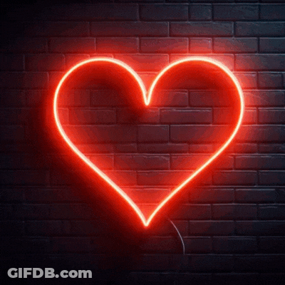 A Red Neon Heart Is Lit Up On A Dark Brick Wall GIF