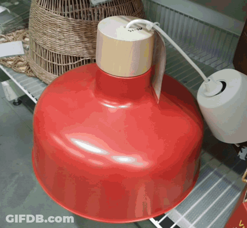 A Red Pendant Light With A Wooden Top GIF