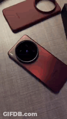 A Red Phone Is Laying On A Table Next To A Box GIF