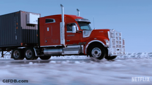 A Red Semi Truck Is Driving Down A Snowy Road With A Netflix Logo Behind It GIF