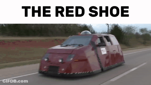 A Red Shoe Van Is Driving Down A Road . GIF