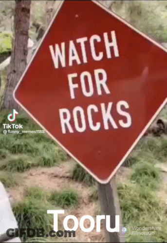 A Red Sign That Says " Watch For Rocks " On It GIF