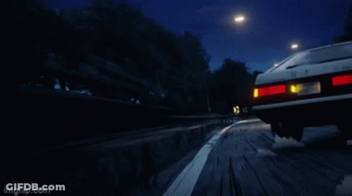 A Red Sports Car And A White Sports Car Are Driving Down A Road GIF
