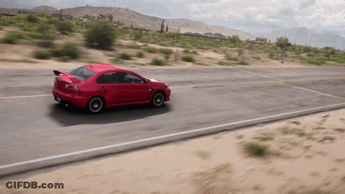 A Red Sports Car Is Driving Down A Desert Road GIF