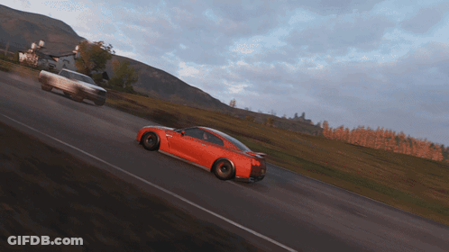 A Red Sports Car Is Driving Down A Road GIF