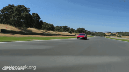 A Red Sports Car Is Driving Down A Road With Motorweek.org Written On The Bottom Right GIF