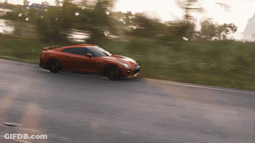 A Red Sports Car Is Driving Down The Road GIF