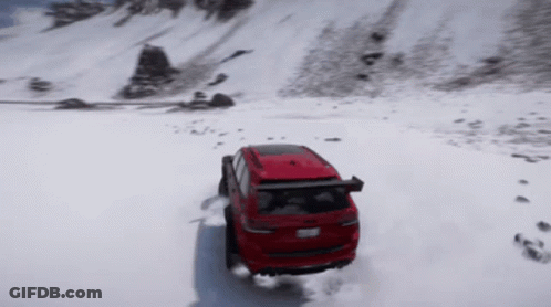 A Red Suv Is Driving Through The Snow On A Mountain GIF