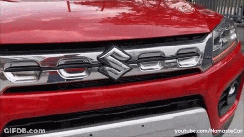 A Red Suzuki Car Is Parked On The Street GIF