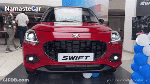 A Red Swift Car Is Displayed At A Dealership GIF