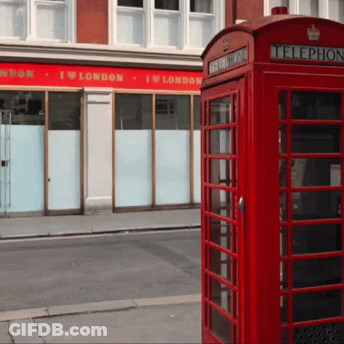 A Red Telephone Booth Sits In Front Of A Building That Says I Love London GIF