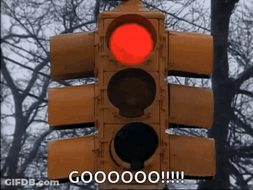 A Red Traffic Light With The Words Goooooo !!! Below It GIF