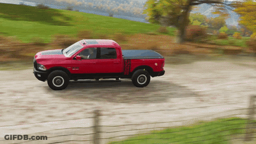 A Red Truck Is Driving Down A Dirt Road GIF
