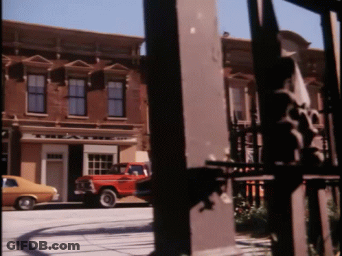 A Red Truck Is Parked In Front Of A Building That Says ' A & A ' On It GIF