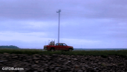 A Red Truck Is Parked In The Middle Of A Rocky Field GIF