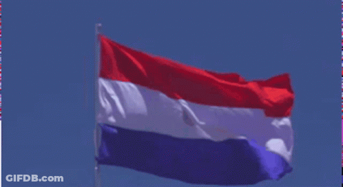 A Red White And Blue Flag Flies In The Wind GIF
