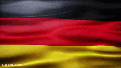 A Red Yellow And Black Flag Is Waving In The Wind GIF