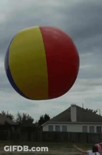 A Red Yellow And Blue Beach Ball Flies In The Air GIF