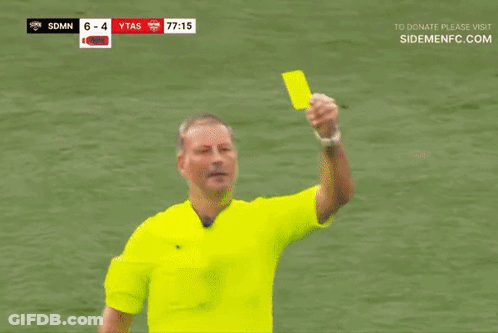 A Referee Giving A Yellow Card To A Player In A Red Shirt GIF