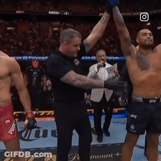 A Referee Holds Up A Shirtless Fighter 'S Arm In A Boxing Ring GIF