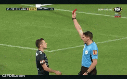 A Referee Is Giving A Red Card To A Player On A Soccer Field . GIF