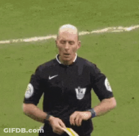 A Referee Is Giving A Yellow Card To A Soccer Player On A Field . GIF
