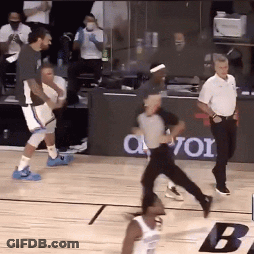 A Referee Is Running Towards A Basketball Player On A Court During A Game . GIF