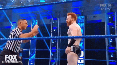 A Referee Is Standing In A Wrestling Ring Talking To A Wrestler During A Fox Deportes Show GIF