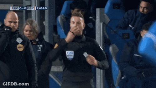 A Referee Is Standing In Front Of A Crowd During A Soccer Game GIF