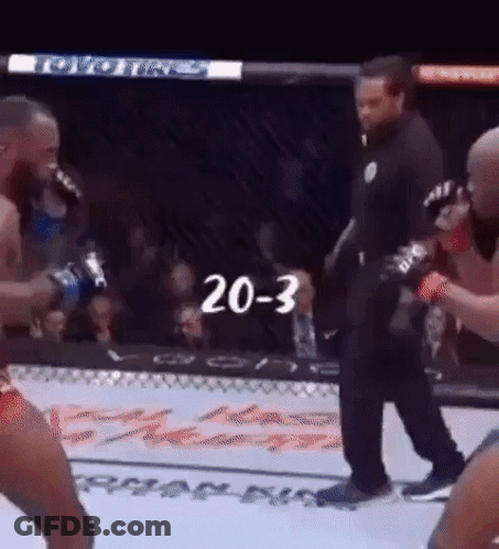 A Referee Is Standing In The Middle Of A Boxing Match With The Number 20-3 Written On The Screen . GIF