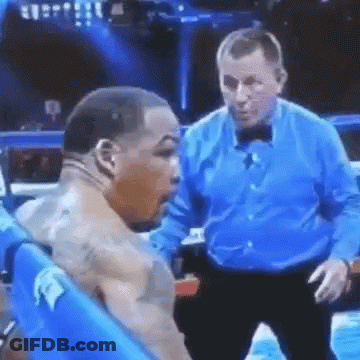 A Referee Is Standing Next To A Boxer In A Boxing Ring . GIF