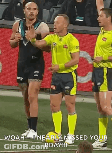 A Referee Is Talking To A Player On A Soccer Field While Another Player Looks On . GIF