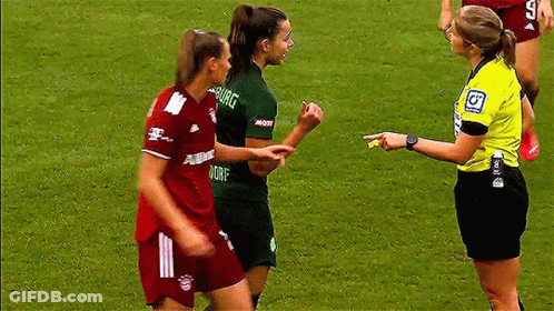 A Referee Is Talking To Two Female Soccer Players One Of Whom Is Wearing A Shirt That Says Dorf GIF