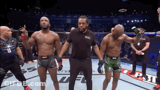 A Referee Stands Between Two Fighters In A Boxing Ring GIF