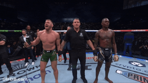 A Referee Stands Between Two Fighters In A Boxing Ring Sponsored By Crypto Com GIF