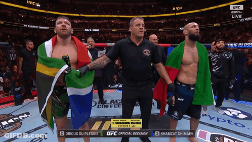 A Referee Stands Between Two Fighters In A Ufc Ring GIF