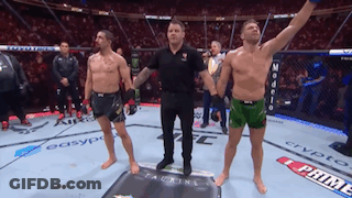 A Referee Stands Between Two Fighters On A Boxing Ring GIF