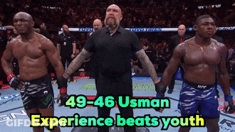 A Referee Stands Between Two Fighters With The Words 49-46 Usman Experience Beats Youth Below Him GIF