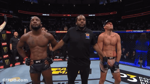 A Referee Stands Between Two Ufc Fighters On A Boxing Ring GIF
