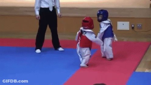 A Referee Stands Between Two Young Karate Players GIF