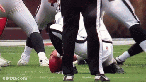A Referee Stands Near A Football Player Wearing Nike Cleats GIF