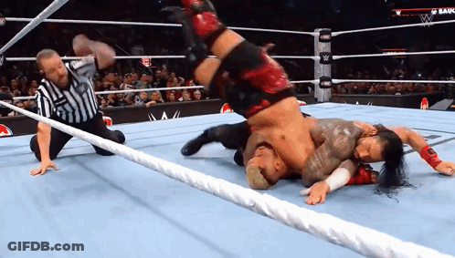 A Referee Watches A Wrestling Match Between Two Wrestlers GIF