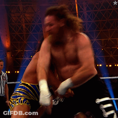 A Referee Watches Two Men Fight In A Wrestling Ring With A Sign That Says Queen On It GIF