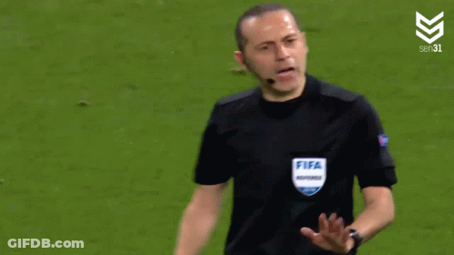 A Referee Wearing A Fifa Referee Shirt Is Talking To A Player GIF