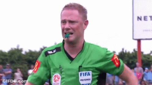 A Referee Wearing A Green Shirt With The Word Fifa On It . GIF