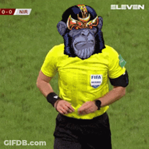 A Referee Wearing A Yellow Shirt With A Monkey Face On His Face GIF