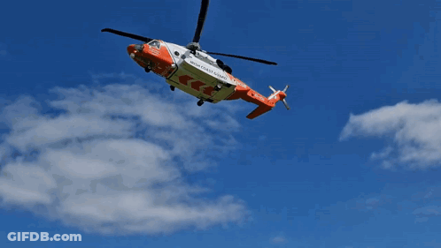 A Rescue Helicopter From The High Coast Guard Is Flying In The Sky GIF